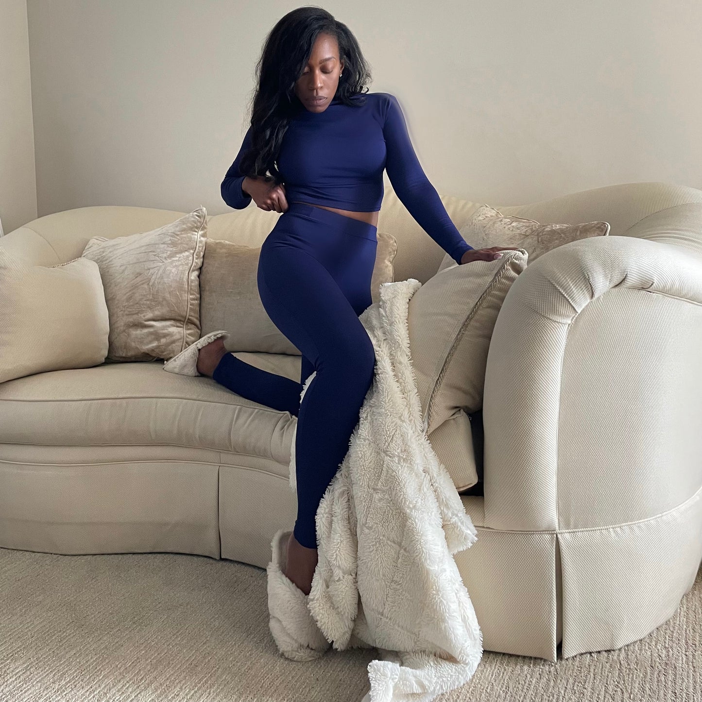 Model on cozy couch wearing High Waisted Leggings for Women EveryDay Stretch Legging in Deep Blue