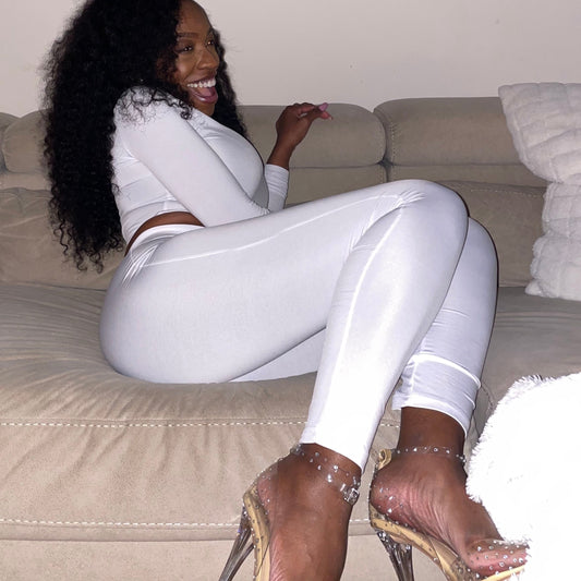 Model smiling on couch wearing High Waisted Leggings for Women EveryDay Stretch Legging in white with high heels